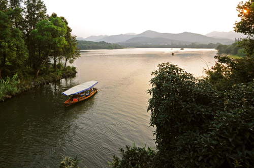一艘游船缓缓驶过杭州西湖茅家埠景区水域.