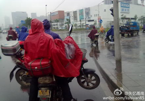 雨天骑车带人又带车 行不得!