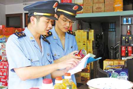 工商执法人员正在认真核对食品进货台账,查清来龙去脉.