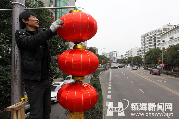 1月29日,招宝山街道的工作人员正在车站路上悬挂大红灯笼,预计在农历