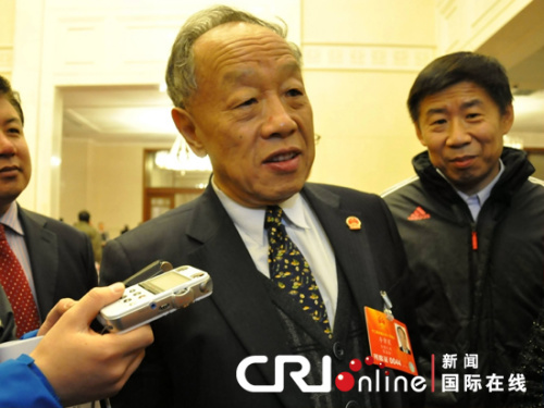 十二届全国人大一次会议在人民大会堂举行第三次全体会议，图为李肇星正与媒体记者“拉家常”。姚毅婧 摄