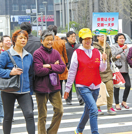 海曙区文明交通志愿者正在引导行人过马路.(陈结生 胡建华 摄)
