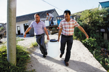 接着用货车送水,偏僻一点的村民家需靠人力抬去.
