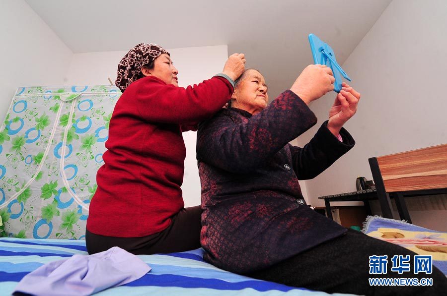 1月26日,银川市大新镇上前城村老年公寓护理员在为王西燕老人梳头。