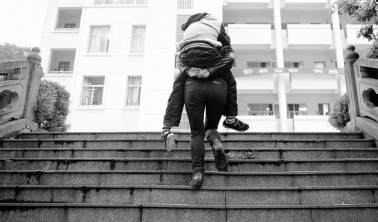 妈妈13年背瘫痪儿子上学 从幼儿园背到高中