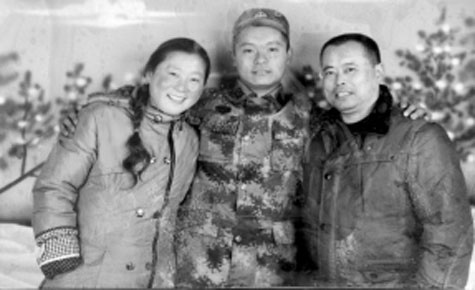 　田志军(右)生前一直放在口袋里的照片 是和参军的儿子及妻子的合影