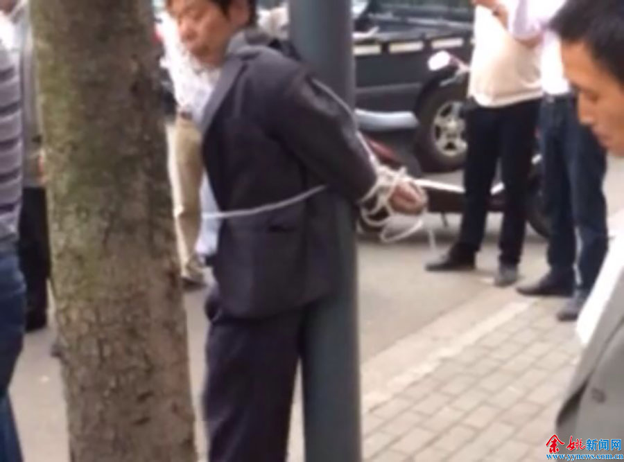 男子疑因骚扰初中女生被绑路灯柱
