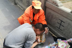 保洁员撑食品袋帮残疾男子吃饭