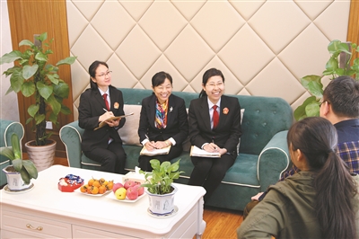 法官俞露烟,调解员潘国飞和书记员在客厅式调解室内调解.