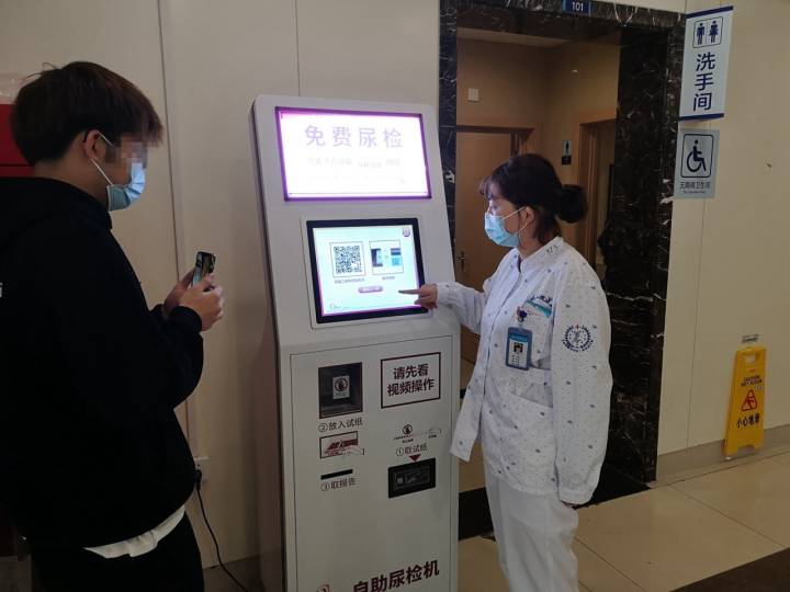 指导患者使用自助尿检机.jpg 指导患者使用自助尿检机.jpg