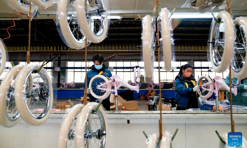 Workers are seen busy on the production line at a factory of a bicycle and baby stroller manufacturer in Pingxiang County, north China's Hebei Province, Dec. 27, 2022. As the end of the year approaches, bicycle and baby stroller manufacturers in Pingxiang County of Hebei Province have stepped up production to guarantee the completion of orders from domestic and foreign customers.(Photo: Xinhua)